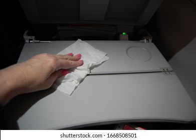 Chicago, Illinois/United States Of America - March 3, 2020: Airline Passenger Wipes Sterilizes And Disinfects The Tray Table On Plane To Prevent Spread Of Coronavirus Germs COVID 19 Flu And Diseases