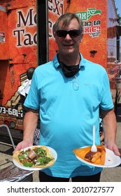 CHICAGO - JULY 2021: Man Holds Plates Of Tacos And Tamales At Latino Street Fair Food Festival In July 2021 In Chicago. The Festival Celebrates Latino Food And Heritage.