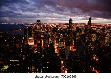 Chicago At Night With Bright City Lights, Skyscrapers, Dark Clouds And Lake Michigan In Illinois The United States