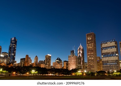 Chicago Skyline Panorama From Park At Night Time. Chicago, Illinois, USA. Skyscrapers Of Financial District, A Vibrant Business Neighborhood.