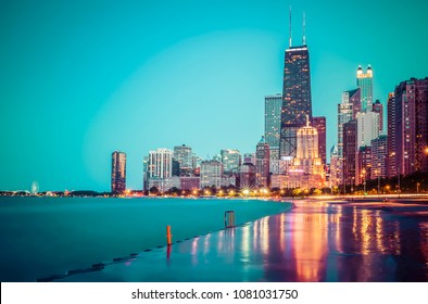 Chicago skyline at sunset with cloudy sky and reflection in water.