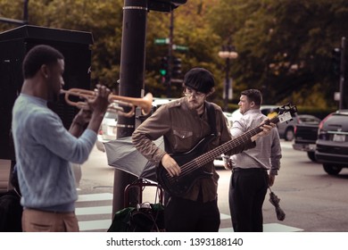 Chicago / USA - 6/12/2015 : A Man Waiting At The Signal To Cross The Street While Two Men Playing Music 