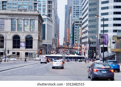 CHICAGO, USA - JANUARY 28, 2018: Busy Chicago Downtown Street With Motorists And An Accordion Style Cta Public Transportation Bus In The Background.