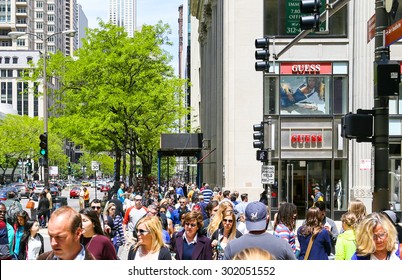 CHICAGO, USA - MAY 24, 2014: A Crowded Shopping Street With Lots Of Pedestrians, Some Green Trees And Retail-Shops.