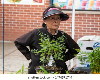 Chicago,IL/USA-July 21st 2019: Older Chinese Lady Is Standing In Front Of Her Shop Waiting For Customers And Tourist  To But Her Goods During The Chinese Summer Festival In Chicago 