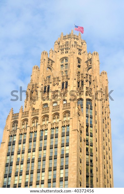 Chicago\'s old Tribune Tower with flag waving in\
the breeze