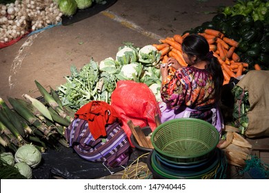 CHICHICASTENANGO, GUATEMALA- MAY 9: An unidentified woman sells vegetables at traditional weekly market in Chichicastenango (Chichi), Guatemala on 9 May 2013
