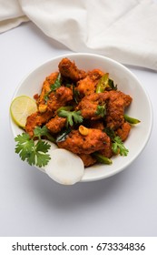 Chicken 65 - spicy deep fried Bar appetizer or quick snack from India in a bowl or plate over white background, selective focus - Shutterstock ID 673334836