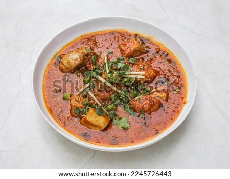chicken achari korma served in plate isolated on table top view of indian and pakistani spicy food
