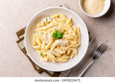 Chicken Alfredo penne, creamy pasta wich parmesan cheese in a white plate. Directly above. - Powered by Shutterstock