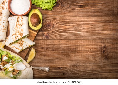 Chicken, Avocado And Vegetables Burrito On The Wooden Background.