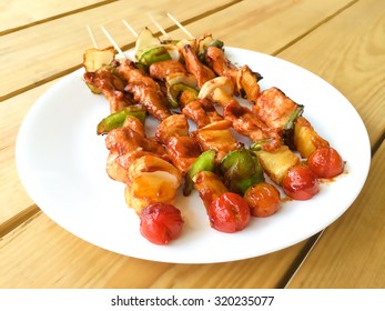 Chicken Barbecue Kabobs On White Plate, Blur Wooden  Background