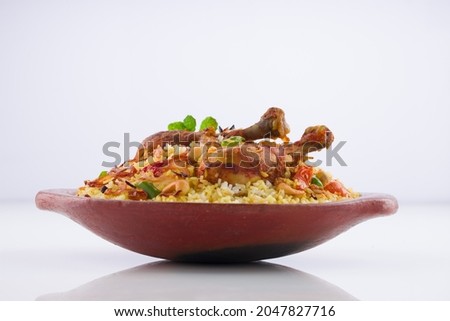 Chicken biryani , kerala style chicken dhum biriyani made using jeera rice and spices arranged in  earthen ware  on white background, isolated