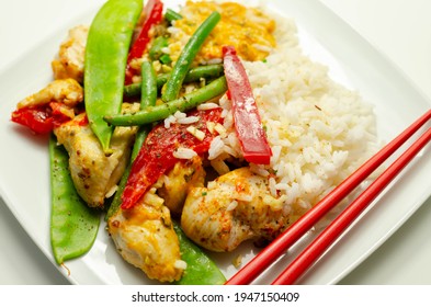 Chicken breast pieces in a Thai red curry sauce made with coconut cream, red chillies, lemongrass, lime leaf, with fragrant rice, red peppers, mange tout, and green beans, Thai food