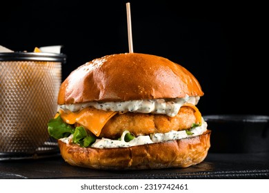 Chicken burger with cheddar cheese, lettuce, sauce, French fries and ketchup, American cuisine. Tasty burger cooking with chicken, cheese and lettuce. - Powered by Shutterstock