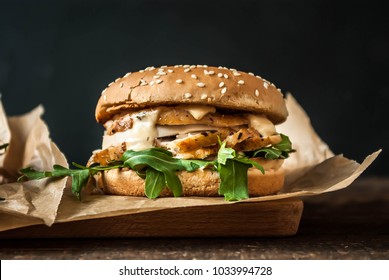 Chicken Burgers With Arugula And Mustard Sauce Served On Paper On A Wooden Board.