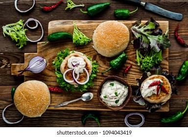 Chicken Burgers With Fresh Salad, Onion, Peppers And Mayonnaise Sauce. Overhead View And Dark, Wooden Background.