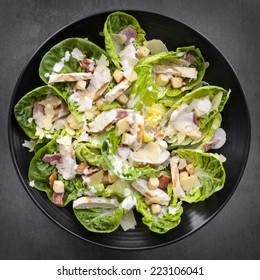 Chicken Caesar Salad On Black Plate Over Slate.  Overhead View.