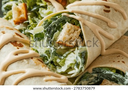 Chicken Caesar Wrap : Grilled chicken Caesar wrap with crisp romaine lettuce, crunchy croutons and creamy dressing wrapped in a soft tortilla, a popular American lunch combining classic salad flavors in a portable meal.