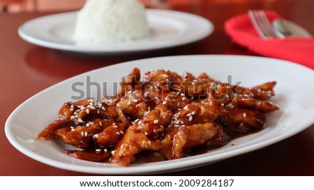 Chicken Cantonese flour fried chicken mixed with canton style sauce sesame sprinkles served with rice on white plate top view