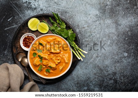 Chicken and cashew red curry, thai inspired dish overhead view with copy space