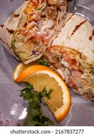 Chicken, Cheese and Vegetable Wrap presented with Orange and Lettuce on a Plate