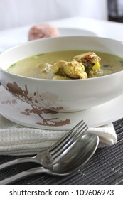 A Chicken Clear soup withe Fork and  Spoon