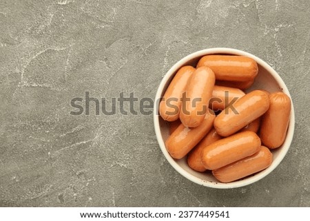 Chicken cocktail sausage on bowl on grey concrete background. Top view