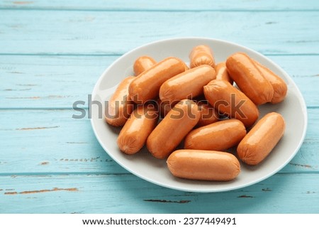 Chicken cocktail sausage on plate on blue wooden background. Space for text. Top view