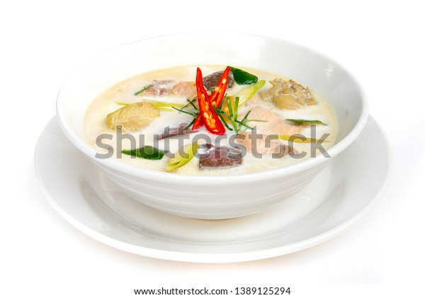 Chicken with\
coconut milk soup (Tom kha gai) Thaifood curry style in white bowl\
side view isolated on white\
background