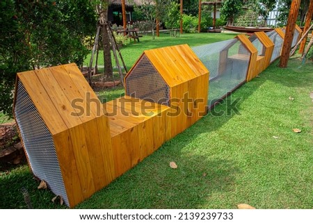 Chicken coop with walkway made of wood and galvanized wire panels with ventilation channels inside laid on the grass.
