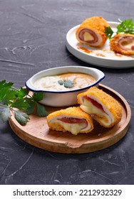 Chicken Cordon Bleu On Wooden Plate With Melted Cheese Oozing Out From Inside