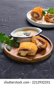 Chicken Cordon Bleu On Wooden Plate With Melted Cheese Oozing Out From Inside