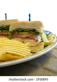 Chicken Cordon Bleu Sandwich With Chips And A Pickle.