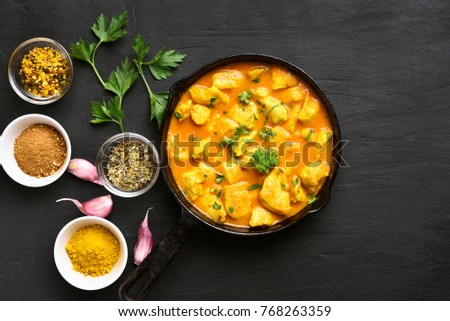 Chicken curry on dark stone background. Top view, flat lay.