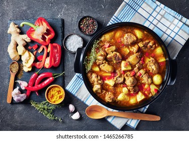 Chicken Curry With Potato, Finely Chopped Red Bell Pepper, Spices In A Black Ceramic Pan, Ingredients At The Background, View From Above, Flatlay