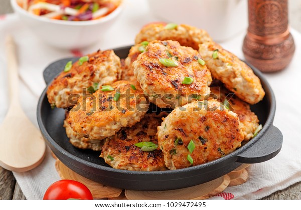 Chicken cutlets in frying\
pan.
