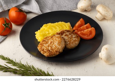 Chicken cutlets with mashed potatoes, steak with mashed potatoes, meat cutlets with mashed potatoes and tomatoes on a plate on a beautiful restaurant background