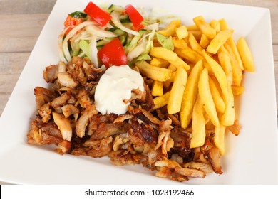 Chicken doner on a plate with fries and salad
