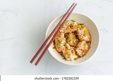 Chicken Dumplings / Wonton In Spicy Sichuan Sauce In A Bowl With Chopsticks Top Down Flat Lay Photo