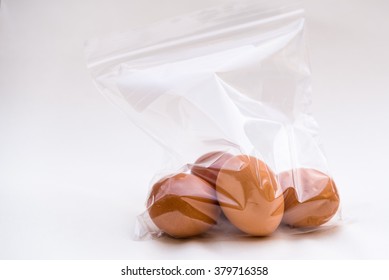 Chicken eggs bagged in plastic bag for storage white background 
Four brown eggs in transparent zip lock bag for storing in fridge, image for kitchen food blog magazines book cover