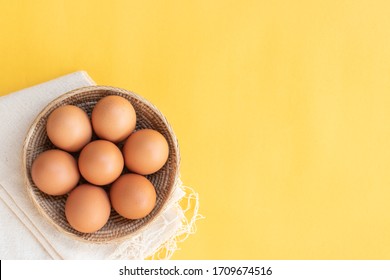 Chicken Eggs, Brown Eggs, Broken Egg In Carton Box On Yellow Background. Top View Natural Eggs In Carton Box Product Concept.