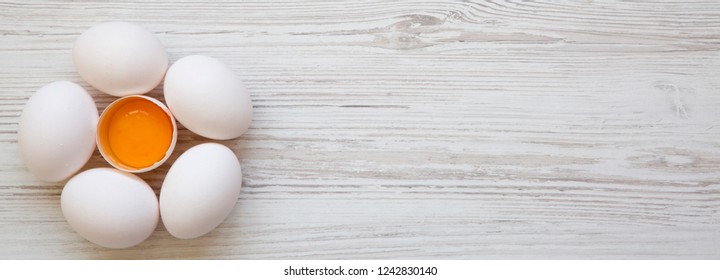 Chicken eggs on white wooden surface, overhead view. Space for text. - Shutterstock ID 1242830140