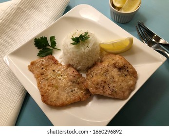 Chicken escalope, also natural roasted cutlet with rice, lemon and sauce. 