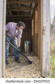 Chicken Farmer Cleaning A Coop Out To Prevent Avian Flu And Other Diseases.