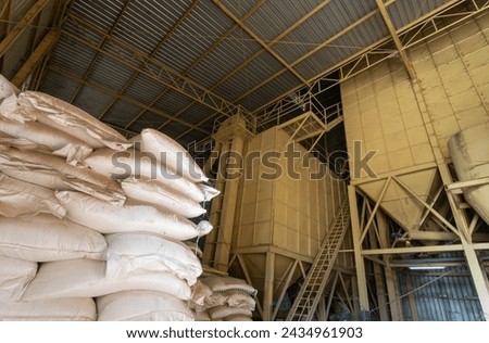 Chicken feed ingredients bags stacked in poultry feed mill plant.