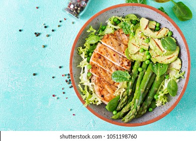 Chicken fillet cooked on a grill with a garnish of asparagus and grilled avokado. Dietary menu. Healthy food. Flat lay. Top view - Powered by Shutterstock