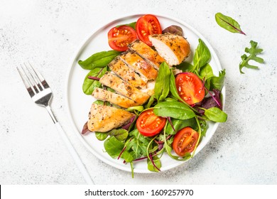 Chicken fillet with salad. Healthy food, keto diet, diet lunch concept. Top view on white background.
