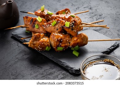 Chicken fillet skewers in yakitori sauce on black slate dishes, dark background. - Powered by Shutterstock