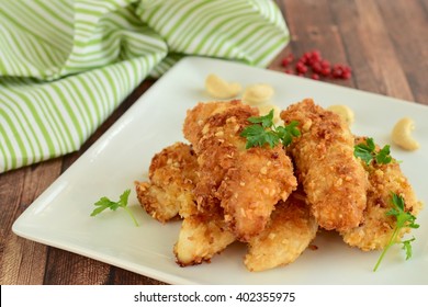 Chicken fingers breaded with cashew and coconut flakes garnish with parsley